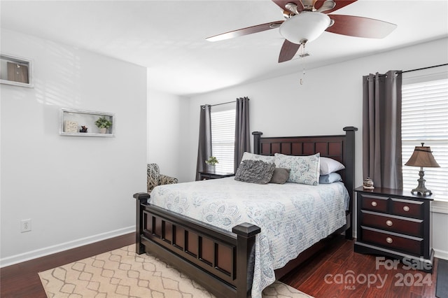 bedroom with multiple windows, dark hardwood / wood-style flooring, and ceiling fan