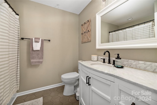 bathroom featuring tile patterned flooring, vanity, and toilet