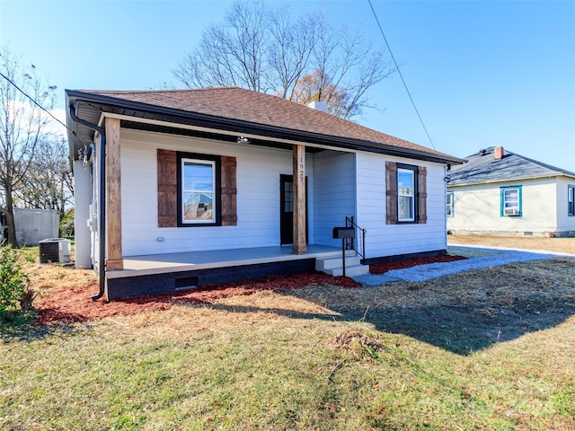 view of front of house featuring cooling unit, a front lawn, and a porch