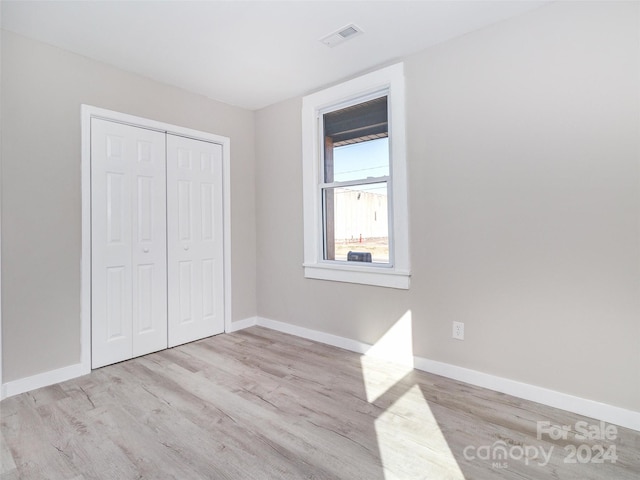 unfurnished bedroom with light hardwood / wood-style floors and a closet