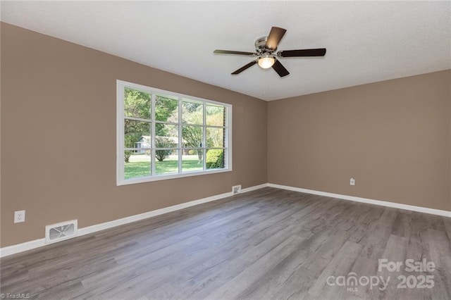 empty room with ceiling fan and light hardwood / wood-style flooring