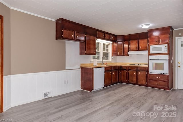 kitchen featuring light wood-type flooring, white appliances, crown molding, and sink