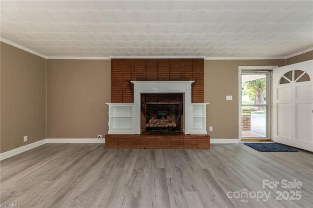 unfurnished living room with crown molding, light hardwood / wood-style floors, and a brick fireplace