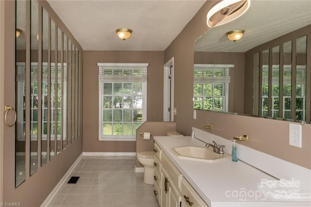 bathroom featuring tile patterned floors, vanity, toilet, and a textured ceiling