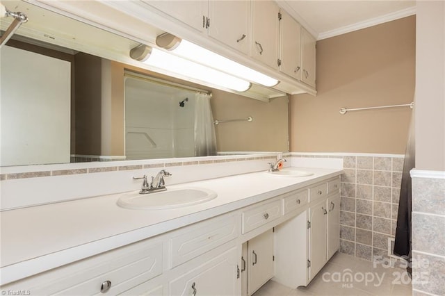 bathroom with tile patterned flooring, vanity, ornamental molding, and tile walls