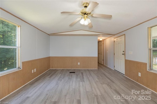 unfurnished room featuring ceiling fan, light hardwood / wood-style floors, and vaulted ceiling