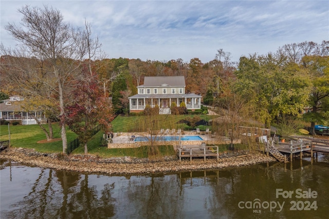 rear view of property with a lawn and a water view