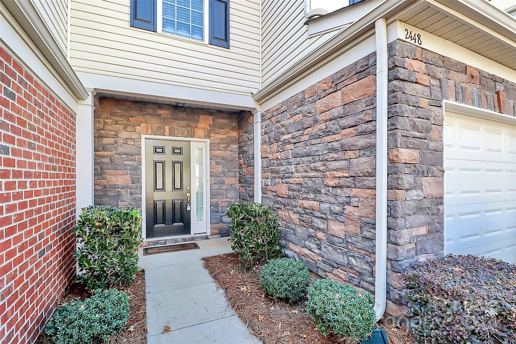 doorway to property with a garage