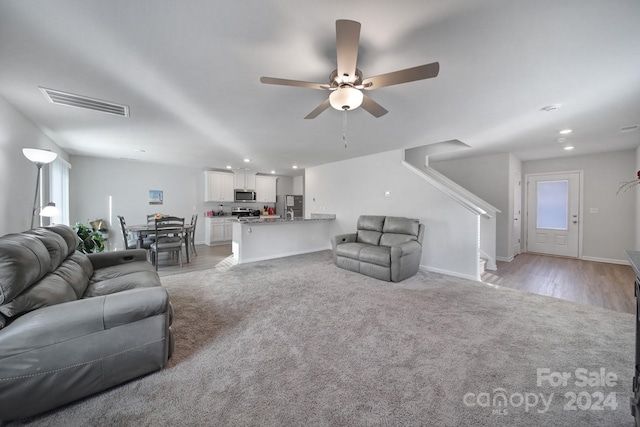 living room with ceiling fan and light hardwood / wood-style floors