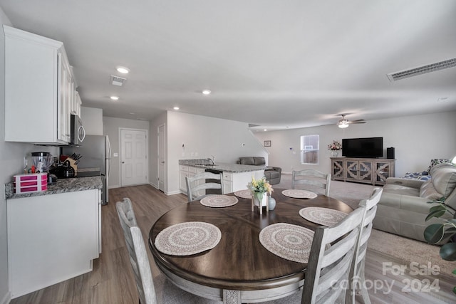 dining room featuring light hardwood / wood-style floors, ceiling fan, and sink