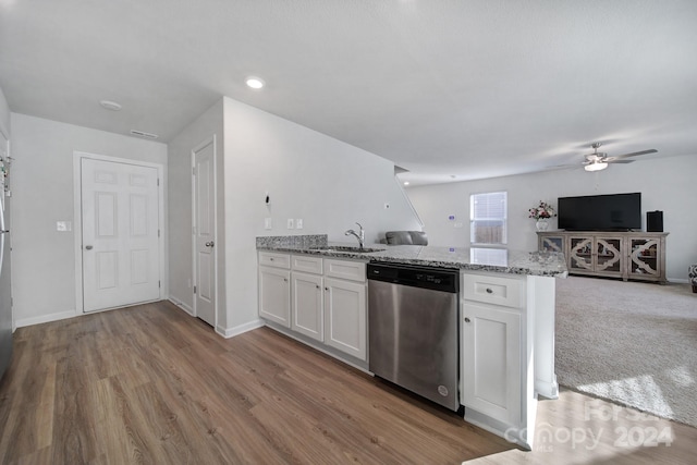 kitchen with sink, stainless steel dishwasher, light stone countertops, light wood-type flooring, and white cabinetry