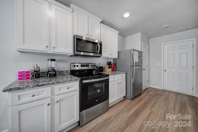 kitchen featuring white cabinetry, stainless steel appliances, stone countertops, and light wood-type flooring