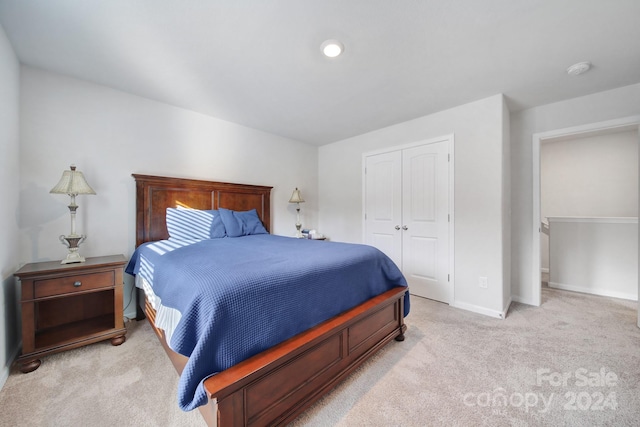 bedroom with light colored carpet and a closet