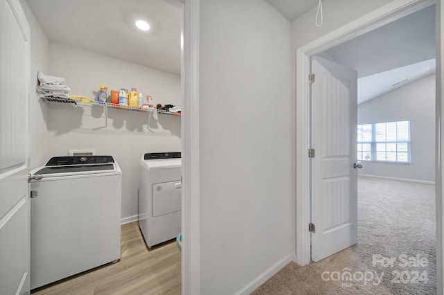 washroom featuring separate washer and dryer and light hardwood / wood-style flooring