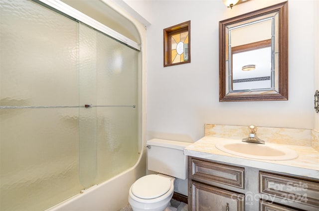 full bathroom featuring vanity, toilet, and combined bath / shower with glass door