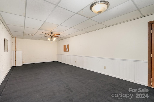 carpeted spare room featuring a paneled ceiling, electric panel, and ceiling fan