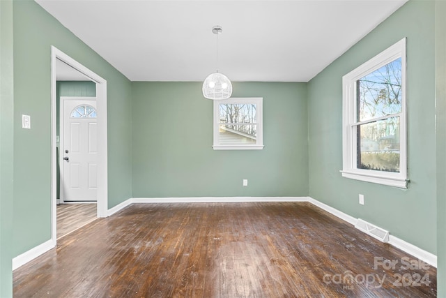 unfurnished room with dark hardwood / wood-style flooring and a wealth of natural light