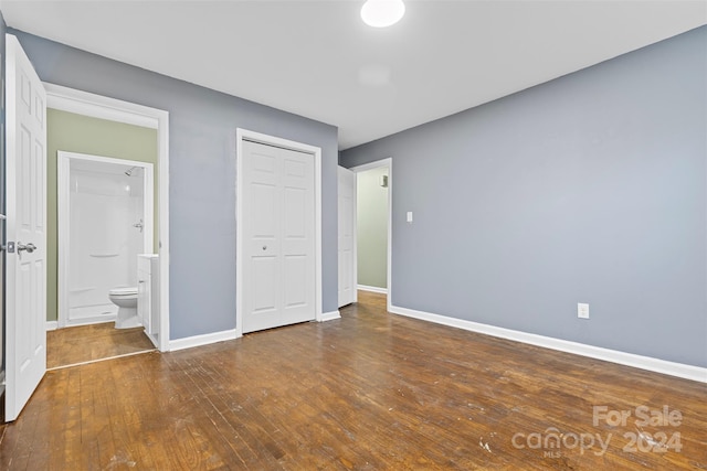 unfurnished bedroom featuring hardwood / wood-style flooring, connected bathroom, and a closet