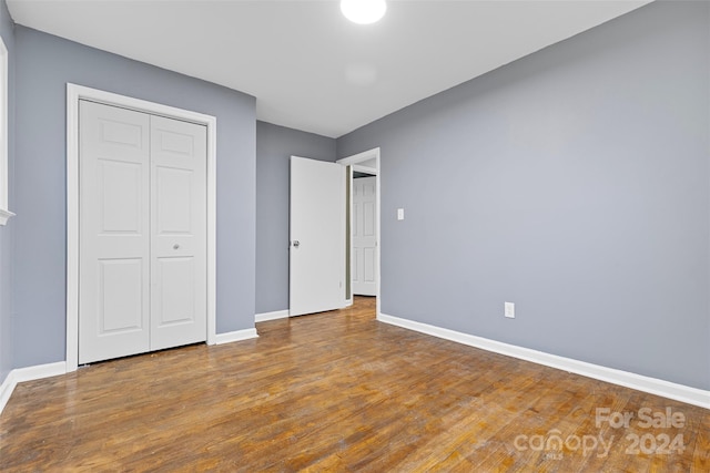 unfurnished bedroom with hardwood / wood-style flooring and a closet