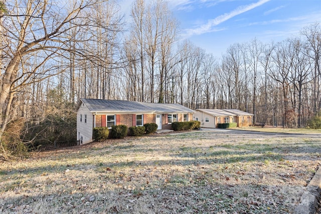 ranch-style home featuring a carport and a front yard