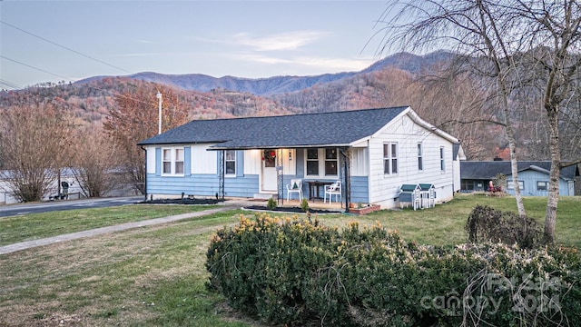 single story home with a mountain view, covered porch, and a front yard