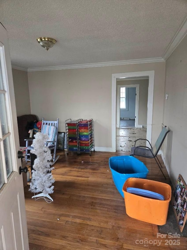 interior space featuring crown molding, dark wood-type flooring, and a textured ceiling