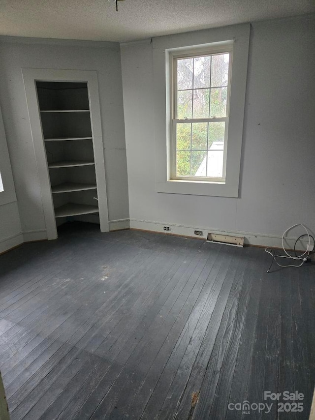 unfurnished bedroom with dark wood-type flooring and a textured ceiling