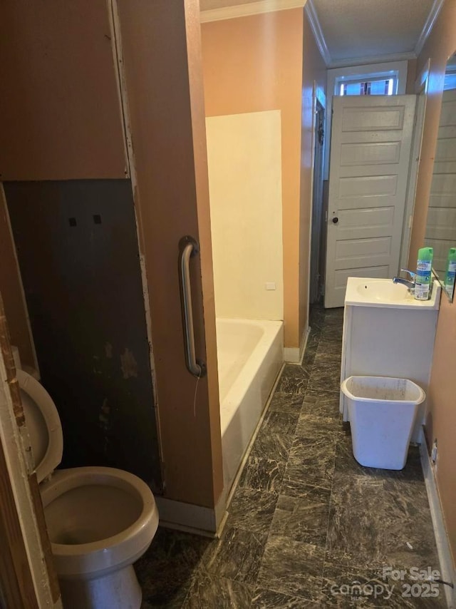 bathroom featuring crown molding, vanity, toilet, and a tub