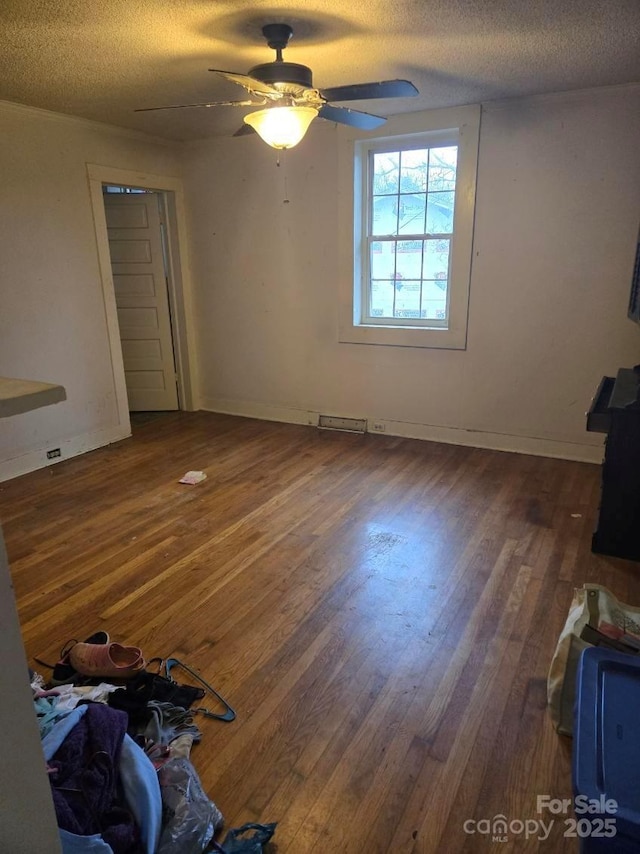 bedroom with dark hardwood / wood-style flooring, ceiling fan, and a textured ceiling