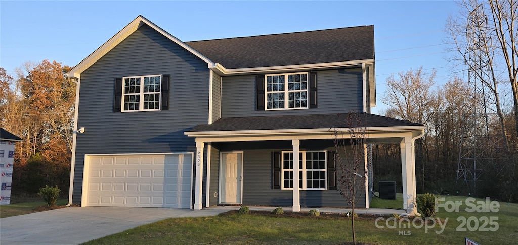 view of front property featuring central AC unit, covered porch, and a garage