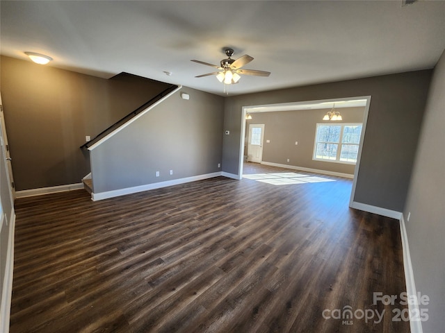 unfurnished living room featuring dark hardwood / wood-style flooring and ceiling fan with notable chandelier