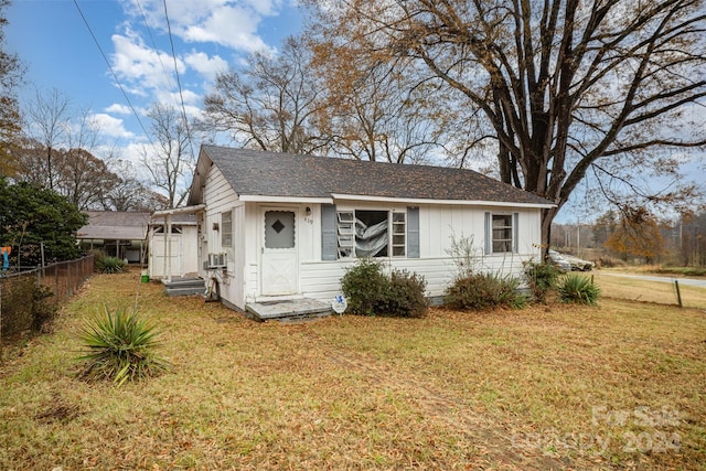 view of front of property with cooling unit and a front yard