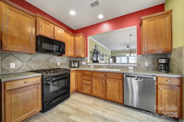 kitchen with sink, light hardwood / wood-style floors, tasteful backsplash, and black appliances