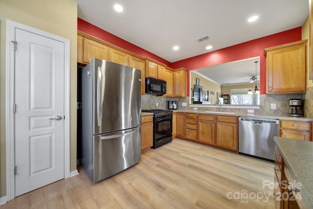 kitchen featuring decorative backsplash, sink, black appliances, and light wood-type flooring