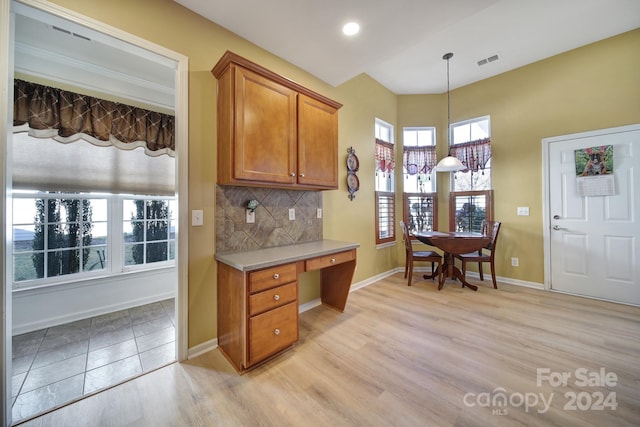 kitchen featuring decorative backsplash, decorative light fixtures, and light hardwood / wood-style floors