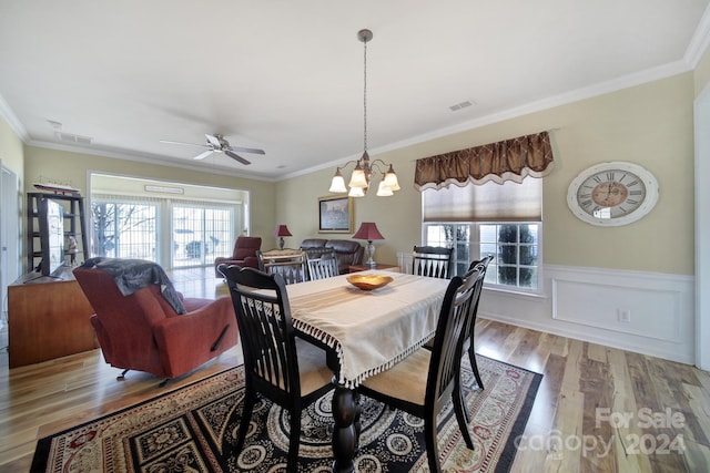 dining area featuring ceiling fan with notable chandelier, light wood-type flooring, and ornamental molding