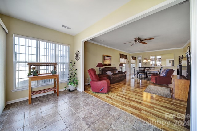 living room featuring ceiling fan, hardwood / wood-style floors, and crown molding