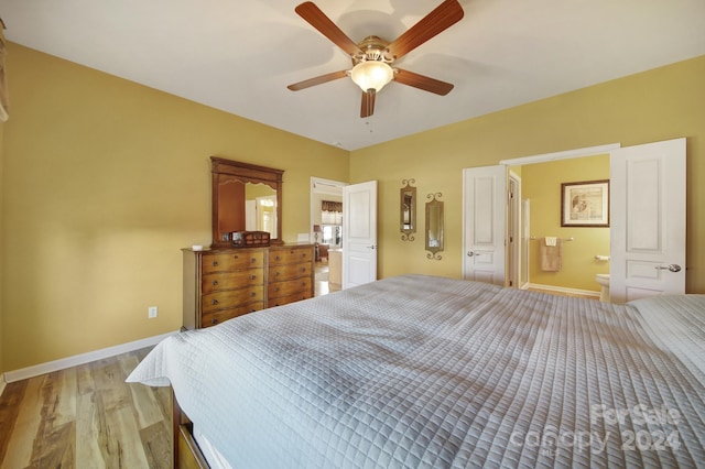 bedroom featuring light wood-type flooring, ensuite bathroom, and ceiling fan