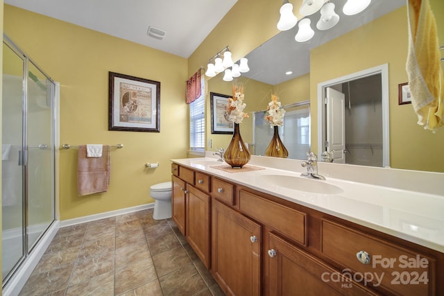 bathroom with vanity, toilet, and a shower with door