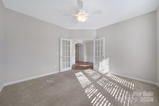 unfurnished room with ceiling fan, carpet floors, and french doors