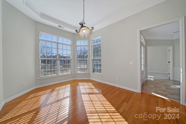 spare room with a chandelier, hardwood / wood-style flooring, and ornamental molding