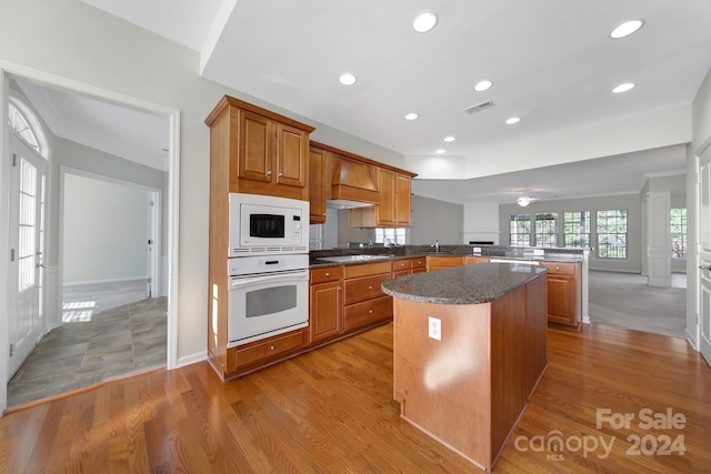 kitchen featuring ceiling fan, a center island, light hardwood / wood-style flooring, kitchen peninsula, and white appliances