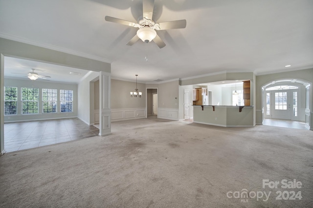 unfurnished living room with light colored carpet, a wealth of natural light, and crown molding