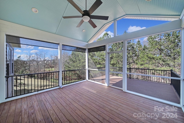 unfurnished sunroom featuring vaulted ceiling, ceiling fan, and a healthy amount of sunlight