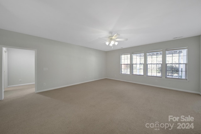 spare room featuring ceiling fan and light colored carpet