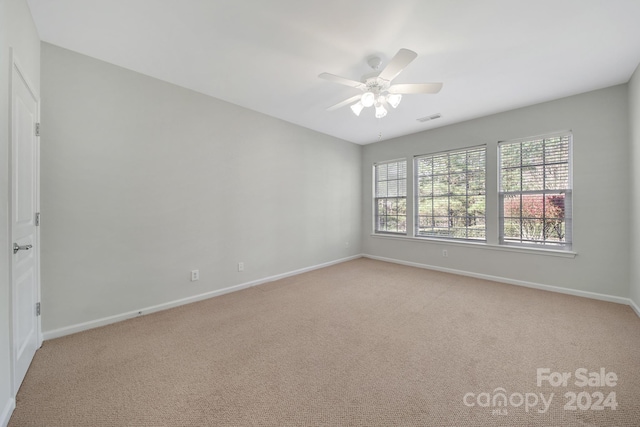 carpeted spare room with ceiling fan