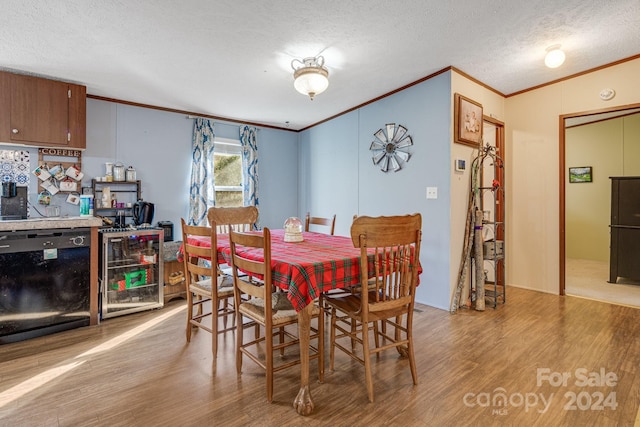 dining space with wine cooler, crown molding, light hardwood / wood-style flooring, and a textured ceiling