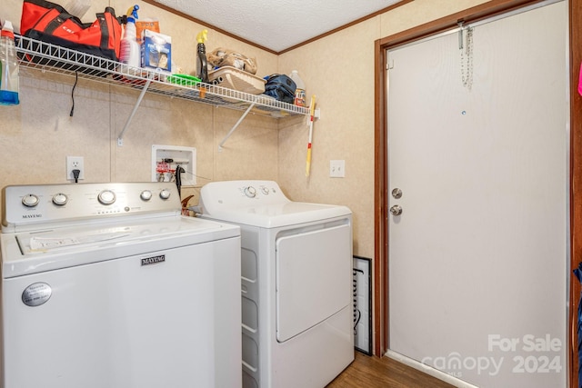 washroom featuring hardwood / wood-style flooring, independent washer and dryer, and a textured ceiling