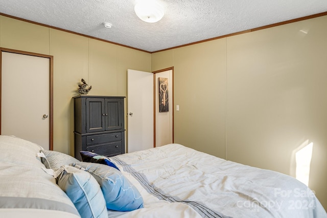 bedroom featuring crown molding and a textured ceiling