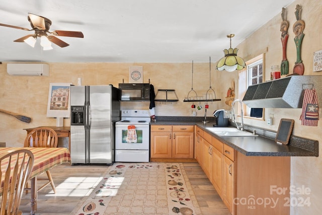 kitchen with electric stove, sink, ceiling fan, stainless steel fridge, and a wall unit AC